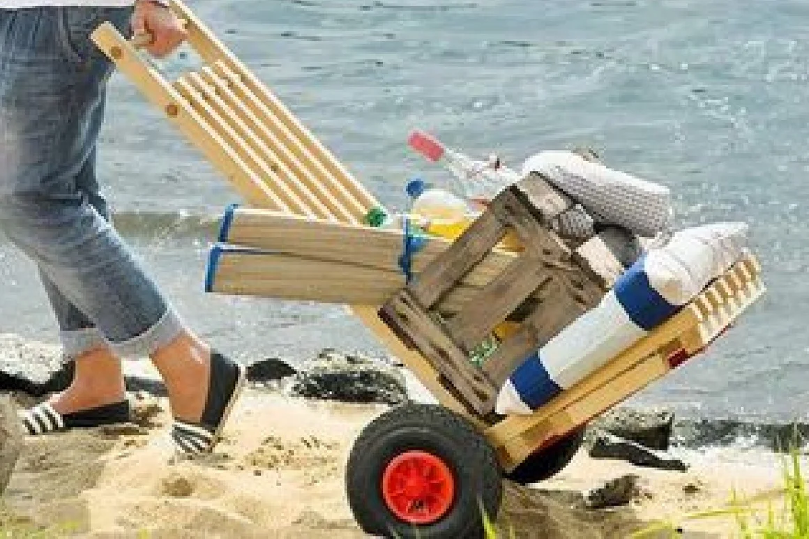 Person zieht selbstgebauten Karren am Strand